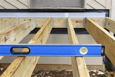 metal attached inside the house to decking|deck joist attached to house.